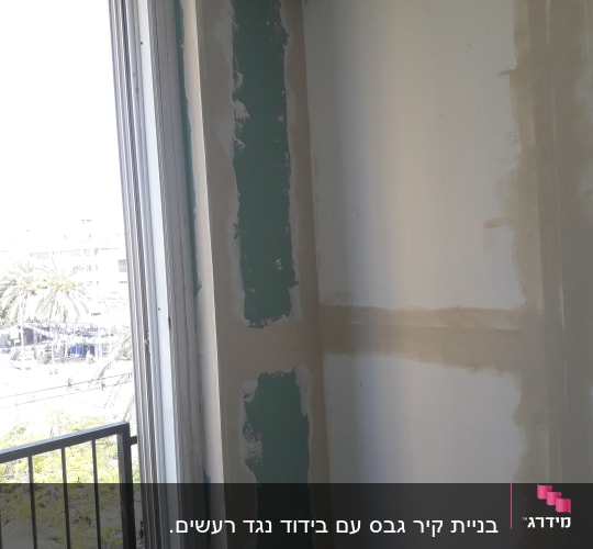 קיר גבס עם תיקוני שפכטל ליד חלון